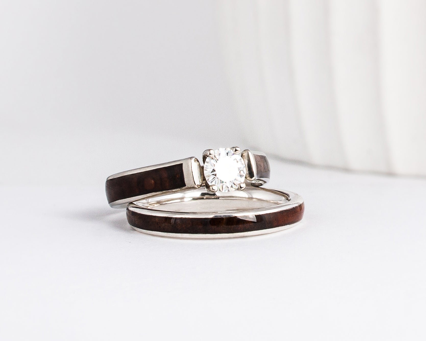 a wood wedding ring set made from white gold, walnut burl wood inlays, and a moissanite solitaire