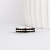 white gold band with straight-styled sleek edge design is inlaid with black ebony wood